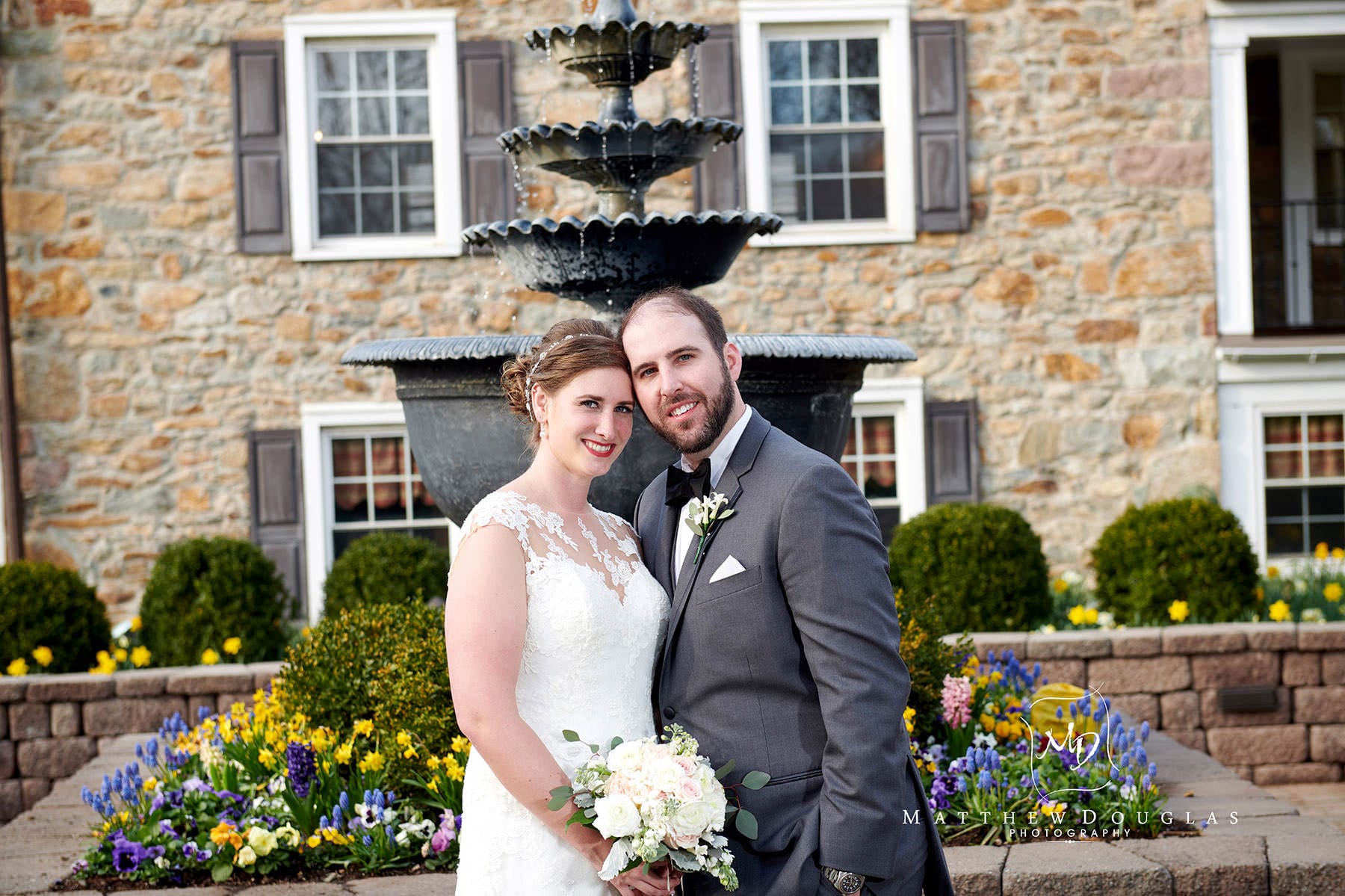 wedding photo in front of the farmhouse at the grand colonial