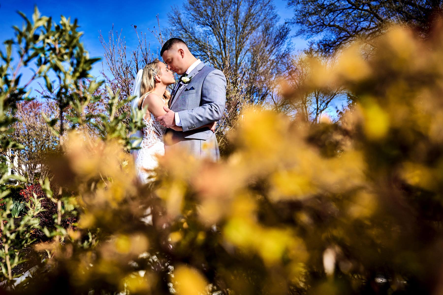 bride and groom framed in colorful folliage at The Farmhouse