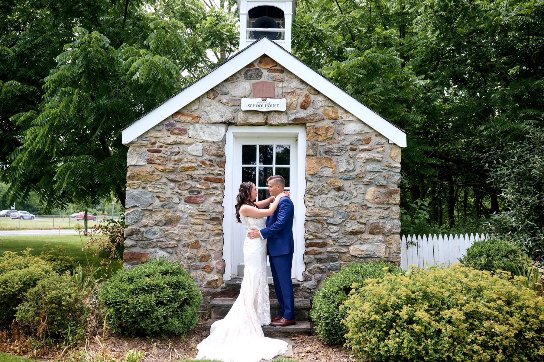 bride and groom by the school house at The Farmhouse