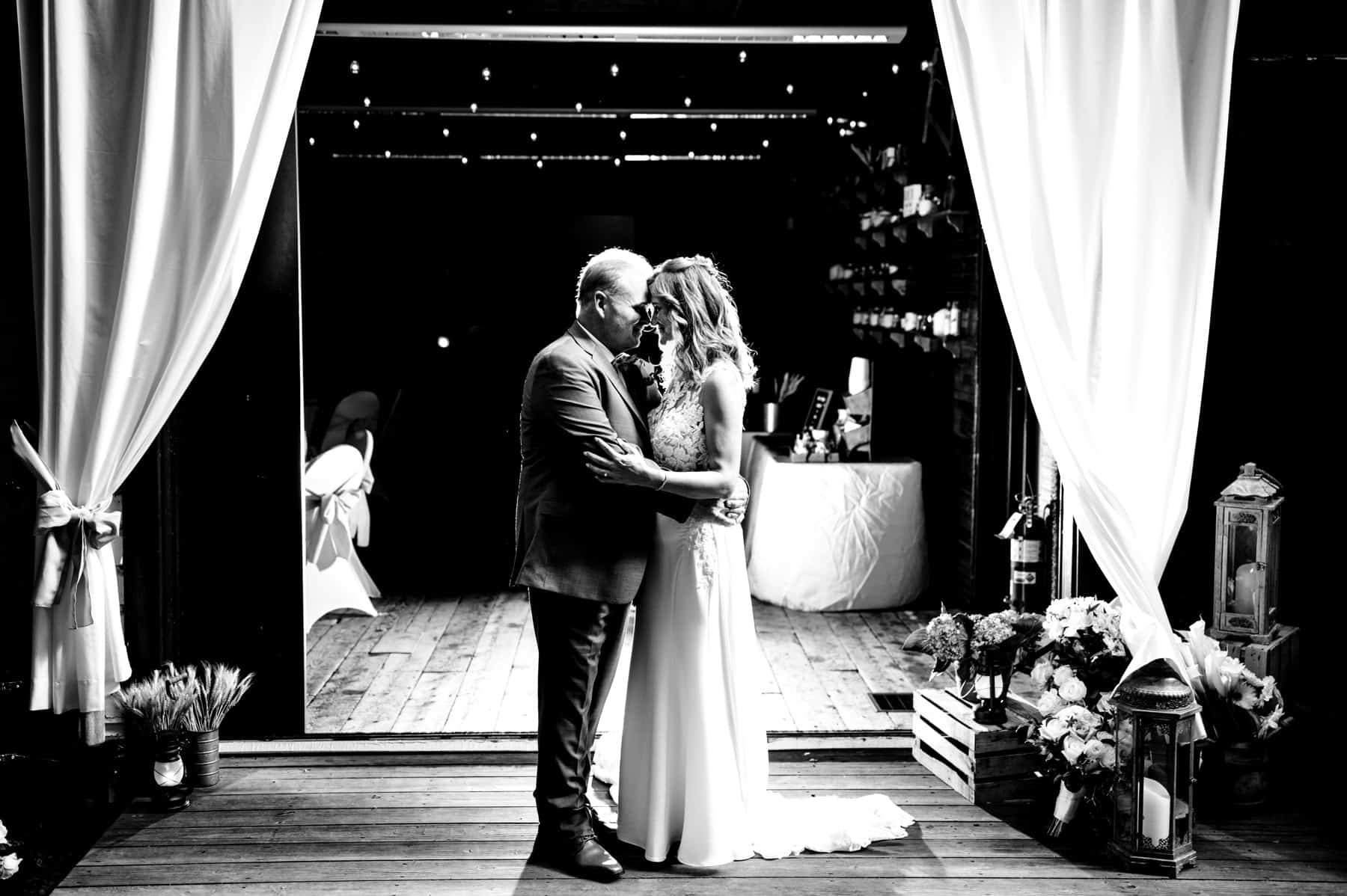 bride and groom in front of Maskers Barn